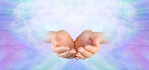Healing offered with Unconditional Love - female cupped hands on a subtle pink purple blue green flowing energy background 
