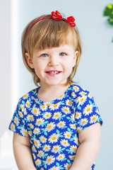 small girl is smiling and flower dress with light background