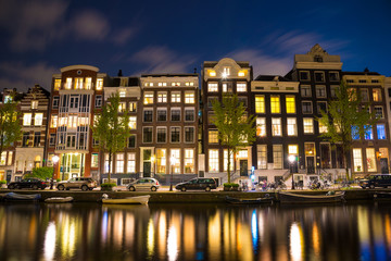 Fototapeta na wymiar Beautiful night in Amsterdam. Night illumination of buildings and boats.