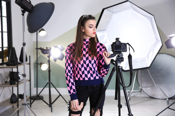 Professional photographer with camera and lighting equipment in studio