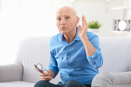 Senior man with hearing aid indoors