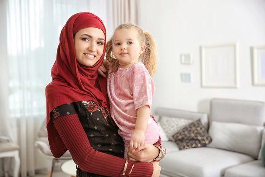 Muslim woman in traditional clothes with her daughter at home