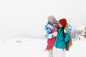 Lovely couple at snowy resort. Winter vacation