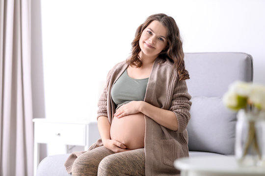 Young pregnant woman in casual clothes at home
