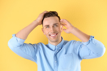 Portrait of young man with beautiful hair on color background