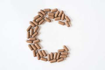 Medicine pills forming letter C, symbolic of vitamin C. healthcare and medical concept