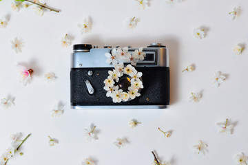 Retro camera with spring flowers on a white background