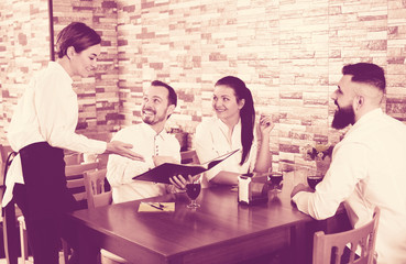 Waitress taking order at table of people