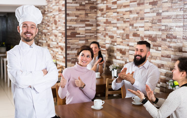Cheerful chef listens to praise of the food