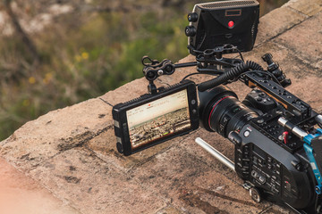 A professional camera is recording the view of a city. The viewfinder is open and showing different...