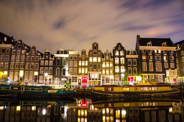 Beautiful night in Amsterdam. Night illumination of buildings and boats.