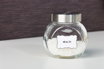 A jar of seasoning with sticker with the word wealth