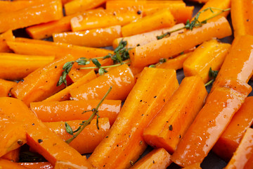 Healthy dietary food.Roasted carrots in oven with olive oil with freshly ground pepper and thyme