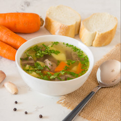 Soup with meat, potatoes and carrot. Beef soup in a white bowl