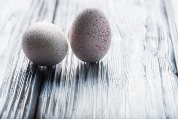 White decorative Easter eggs on light wooden background.