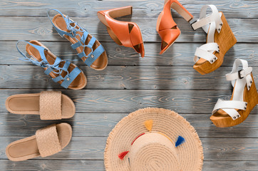 Set of womens shoes (wedges, heels and flat sandals) on grey wooden background. Spring summer...