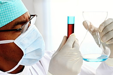 COVID-19 Coronavirus  pandemic global outbreak scientist testing chemical fluid in laboratory with face dust mask fighting the disease on white background stock photo