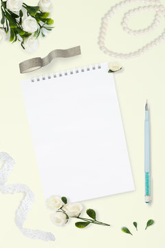 Styled stock photo. Feminine wedding desktop mockup. White roses, satin ribbon, beads on pastel gray background. Copy space. Top view. Picture for blog