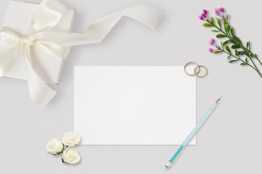 Styled stock photo. Feminine wedding desktop mockup. White roses, satin ribbon, beads on pastel gray background. Copy space. Top view. Picture for blog.