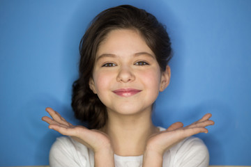 Portrait of young stylish freckled girl laughing with hand on cheek looking at camera. Copy space.