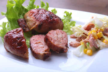 Marinated roaste chicken breasts cooked on BBQ and served with fresh salad on white plate, close-up.