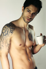 Bel homme sexy tenant une tasse à café 