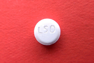 Tablet LSD on red - obrazy, fototapety, plakaty