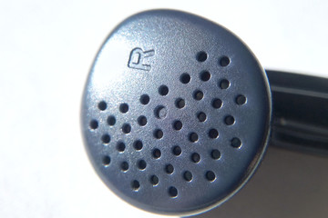 The right earphone on white background close-up blurred background