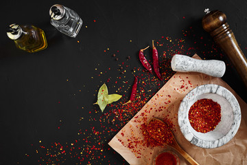 Dried and crushed red chili pepper in stone mortar. Copy space