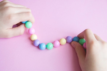gently spring multi-colored beads in children's hands