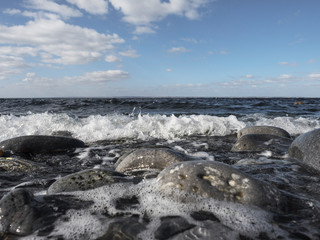 Cloudy sky over Atlantic ocean, wave hitting the coast. 