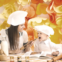 A happy mother and her child in the form of cooks prepare a delicious lunch