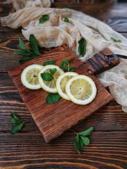 sliced and whole lemon on wooden chopping Board
