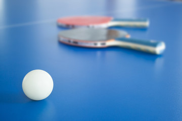 White ping-pong ball with rackets on background