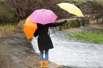femme marchant dans une rivière avec des parapluies de couleurs