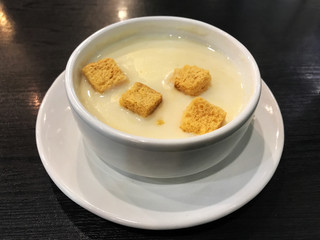 biscuit on top corn soup in white bowl on the black wooden table.