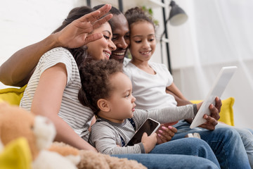 happy young family making video call with tablet at home