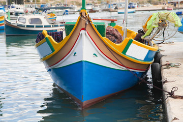 Fototapeta na wymiar Colourful maltese boat in Marsaxlokk Harbor