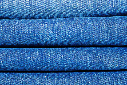 A stack of several classic jeans in a closet for clothes