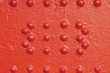 Red rivets on the old sheet steel painted in red color