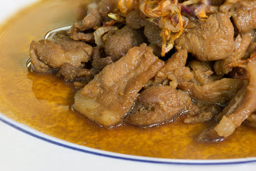 Stir pork slice with coconut sugar sprinkle with fried shallot slice (Sweet pork) in white dish Thai food.