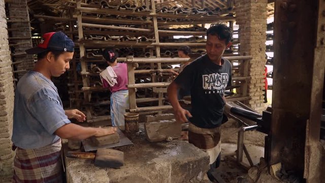 Men and women working at manual clay roof tiles making factory in Kebumen, Indonesia