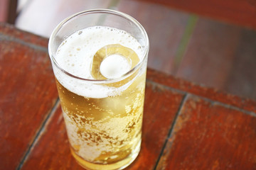 Glass of beer on wood table background close up