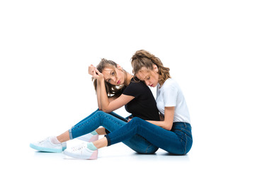 attractive young twins sitting of floor on white