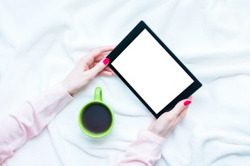woman uses tablet pc, women's hands, lying on the blanket, red manicure, white background with copy space, for advertising, top view