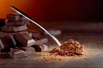 Broken  chocolate pieces and cocoa powder .