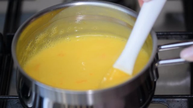 Freshly prepared lemon kurd - custard on fruit juice, in a saucepan whipped with whisk