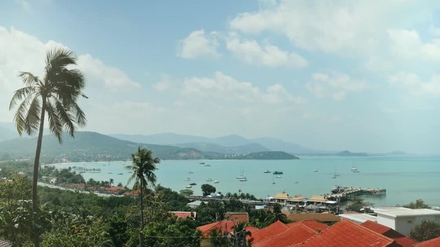Bright sun coming out behing cloud on blue sky over ship and sea yachts