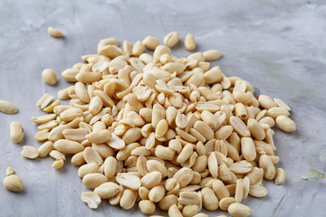 Pile of peelled peanuts isolated on white textured background, background, top view, close-up, selective focus