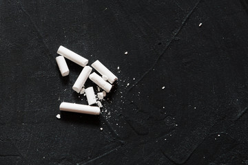 A few pieces of white chalk lie on the board for writing your own work. DIY. Hand made. Copy space..